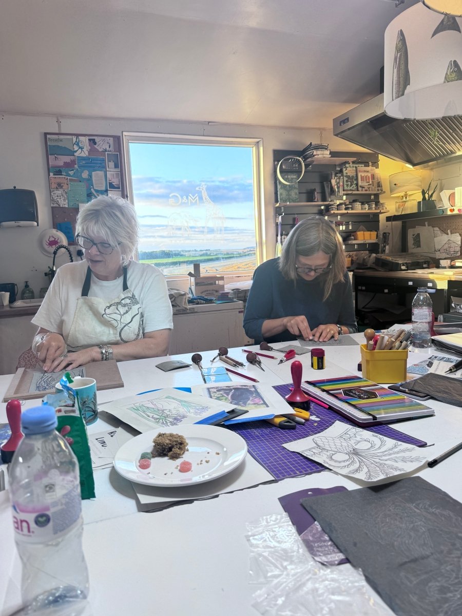 Couple of ladies at a Lino workshop set in the countryside with a nice view behind