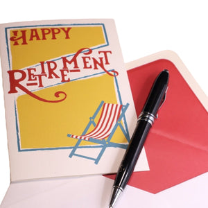 a happy retirement card with a pen on top of it