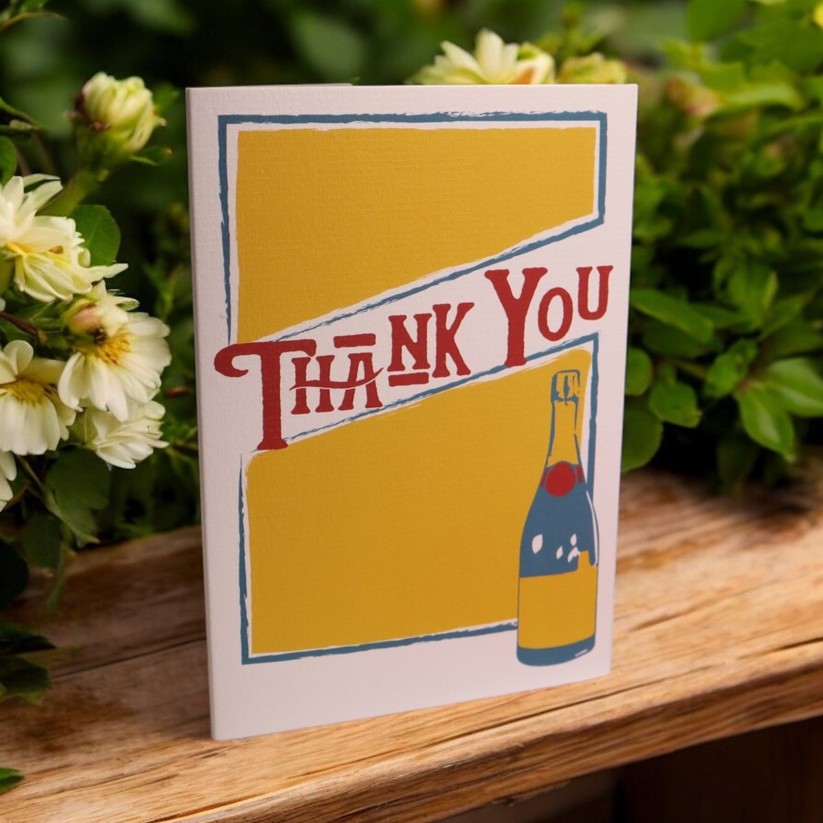 a thank you card sitting on top of a wooden table