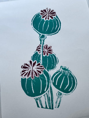 Two-colour jigsaw linocut print of poppy seed heads in teal green and burgundy.