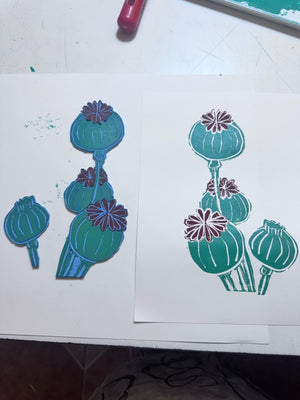 Jigsaw linocut blocks and finished two-colour print of poppy seed heads in teal and burgundy.