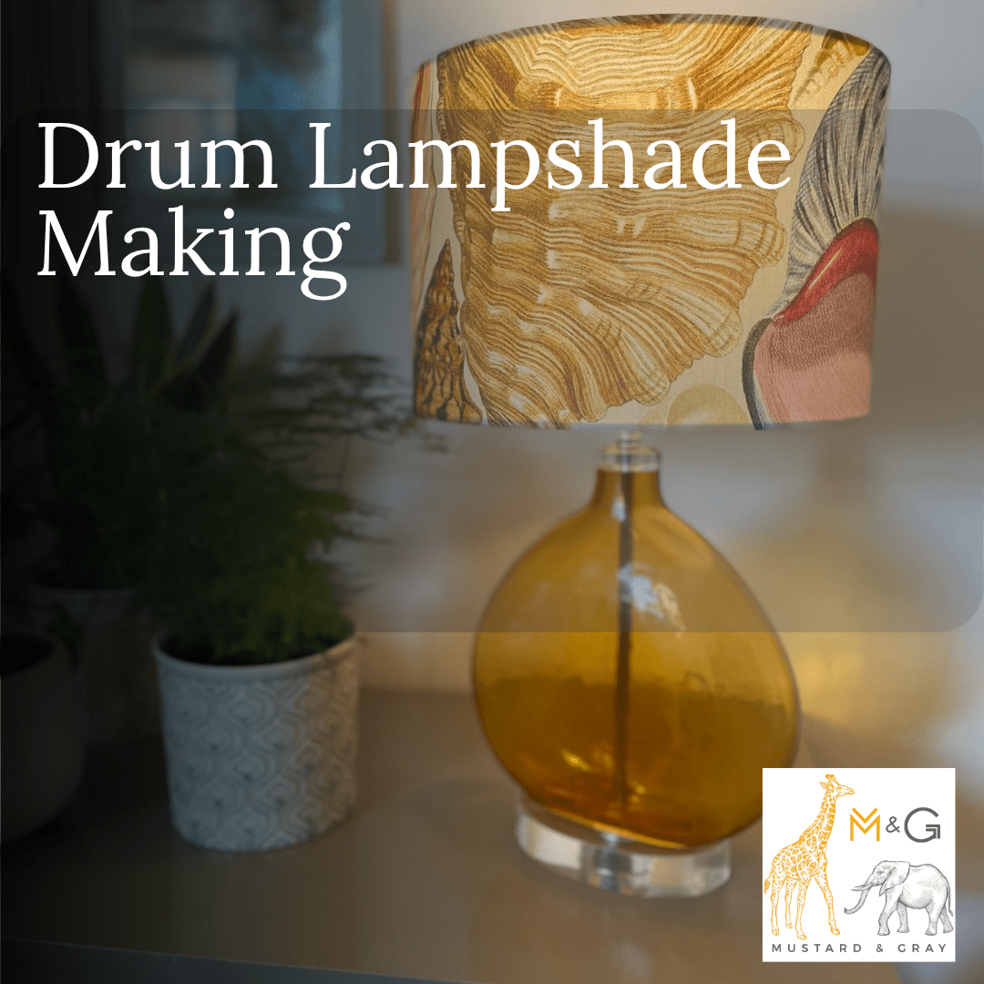 Drum lampshade with a decorative shell pattern on an amber glass lamp on a blurred background with a plant. 
