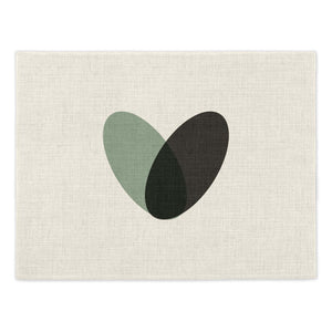 Toco Heart Placemat. Single linen effect placements featuring a graphic heart design made from two overlaid ovals, one in black and one in green. Mustard & Gray Placemats.