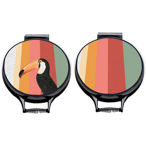 Set of two. Toco Toucan illustration print with stripes of green, red, pink and orange on beige linen circular hob cover with black hemming. Chefs hob cover. Pictured on metal cooker lid on an isolated background. Mustard and Gray