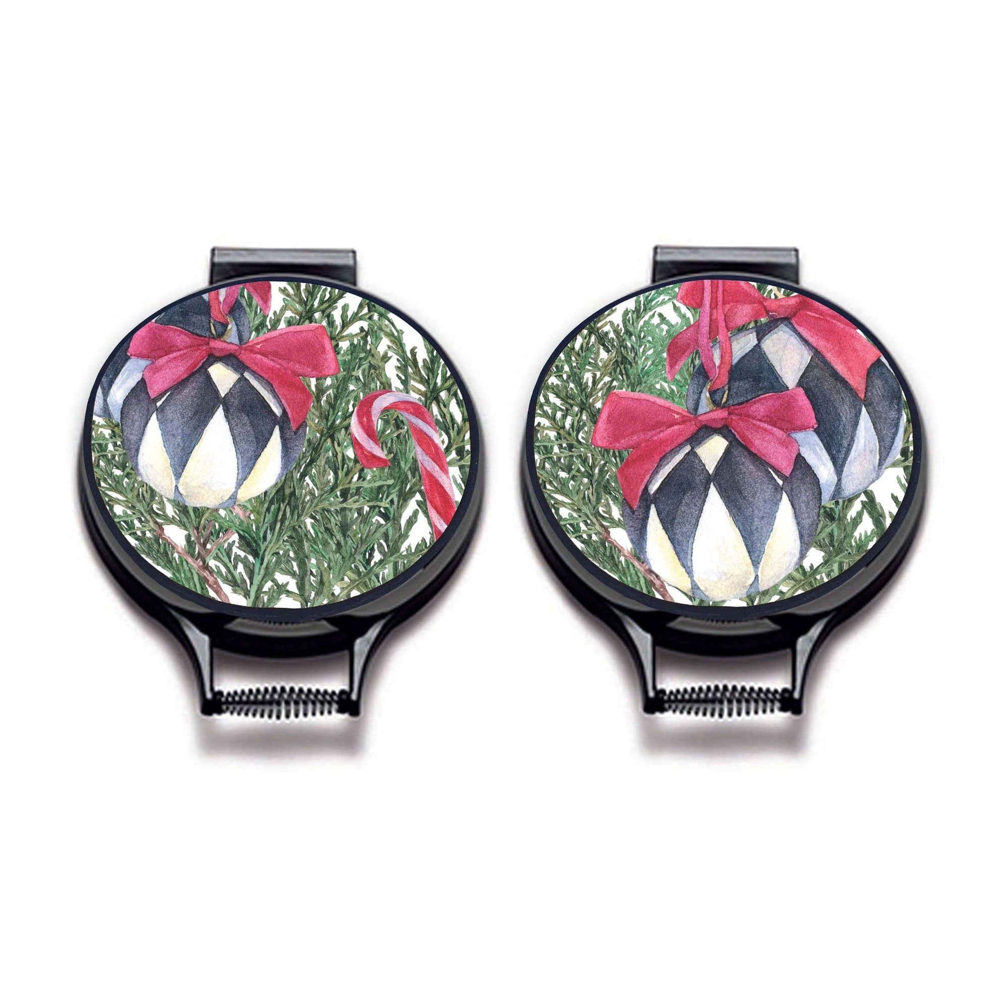 Set of two. Illustration of Christmas tree bows with lack and white baubles with red bows, candy canes, oranges and xmas decorations on linen circular hob cover with black hemming. Pictured on metal cooker lid on an isolated background. Mustard and Gray
