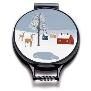 winter fox scandi modern print on a beige whith village scene including blue sky, , deer houses and pond linen circular hob cover with black hemming. Pictured on metal cooker lid on an isolated background. Mustard and Gray